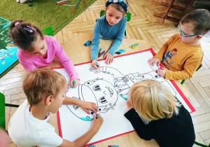 Dzieci uzupełniają kolorowankę "Listonosz" według kodu